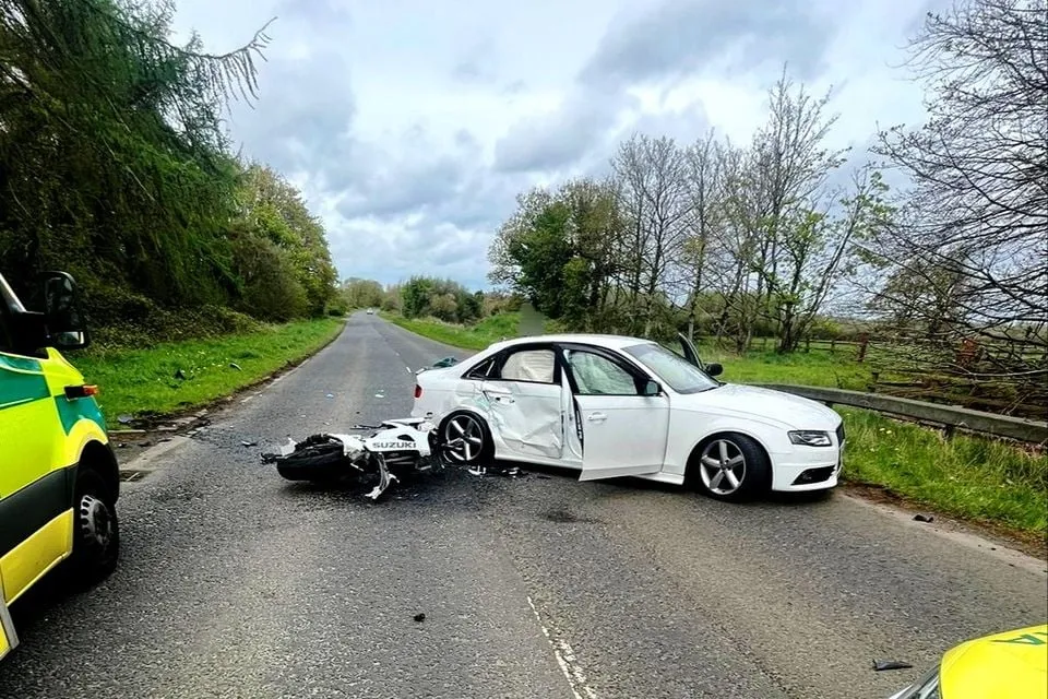 Motorcycle and car accident on a road.