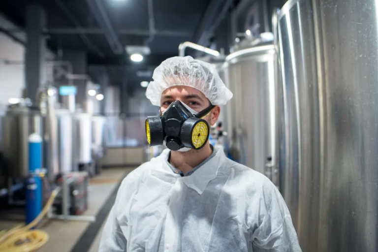 Industrial worker wearing a respirator in a factory, symbolising chemical and gas inhalation compensation claims in the UK.