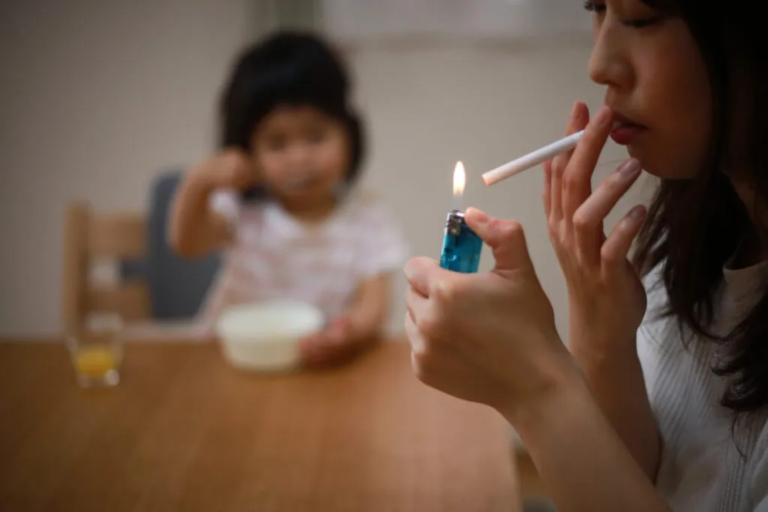 Non-smoker exposed to secondhand smoke in an indoor setting, illustrating passive smoking compensation claims in the UK.